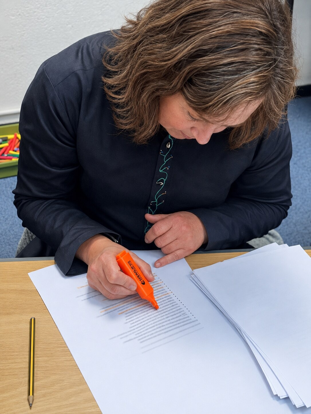 Staff member using an orange highlighter to complete a training worksheet
